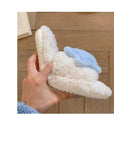 Creamy white fluffy plush home slippers with asymmetrical decorations of cute stars and moons